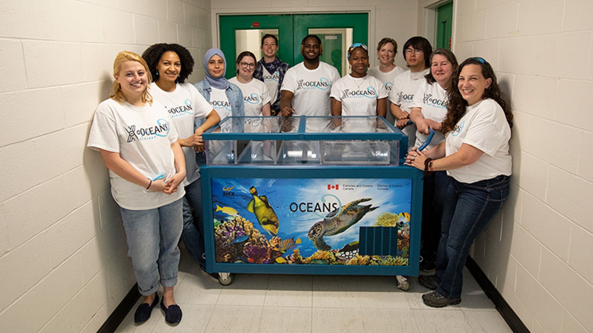 Members of X-Oceans around a touch-tank