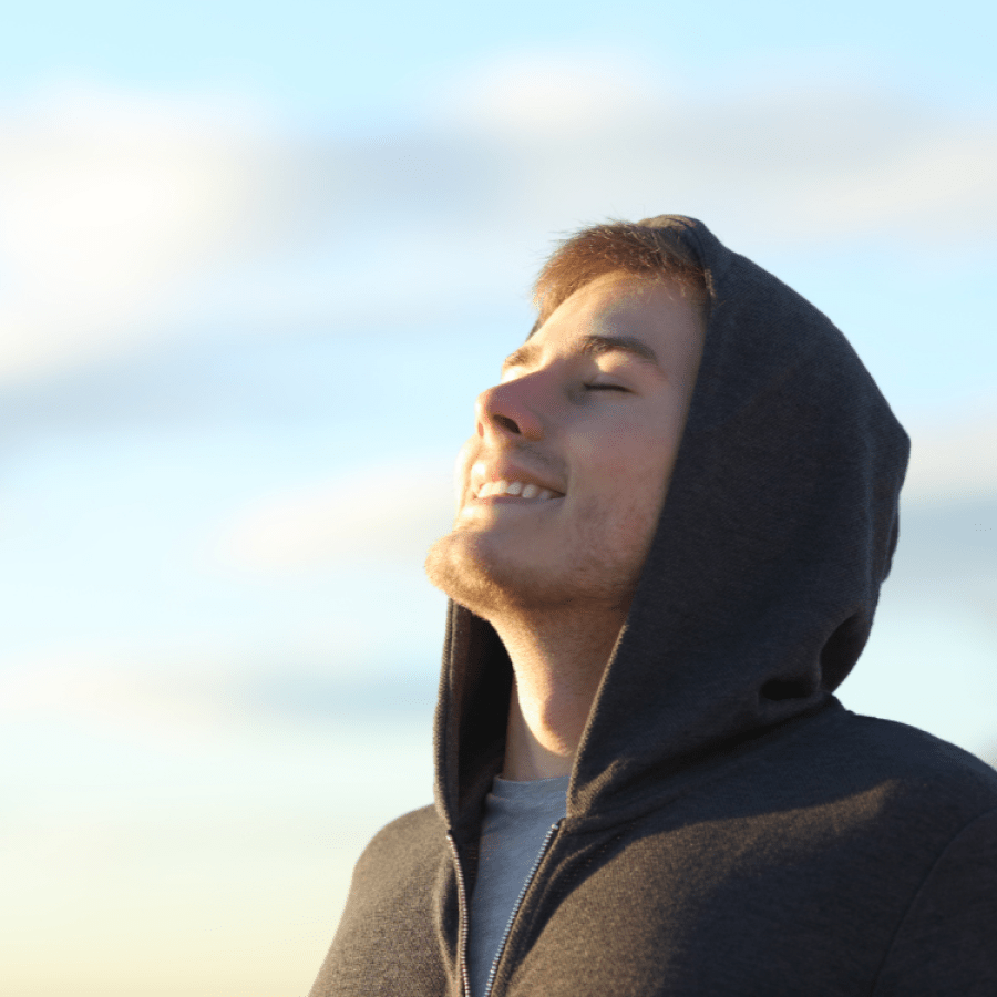 A young person wearing a hoodie smiling