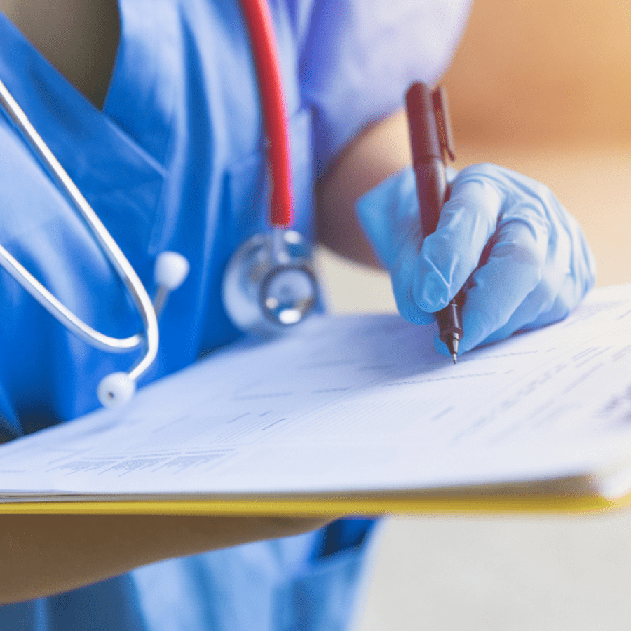 A nurse writing on a clipboard