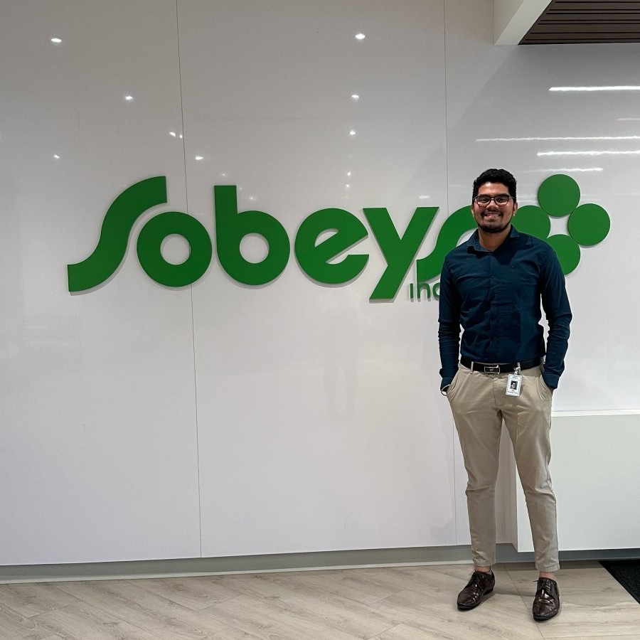 Co-op student standing in front of Sobeys logo